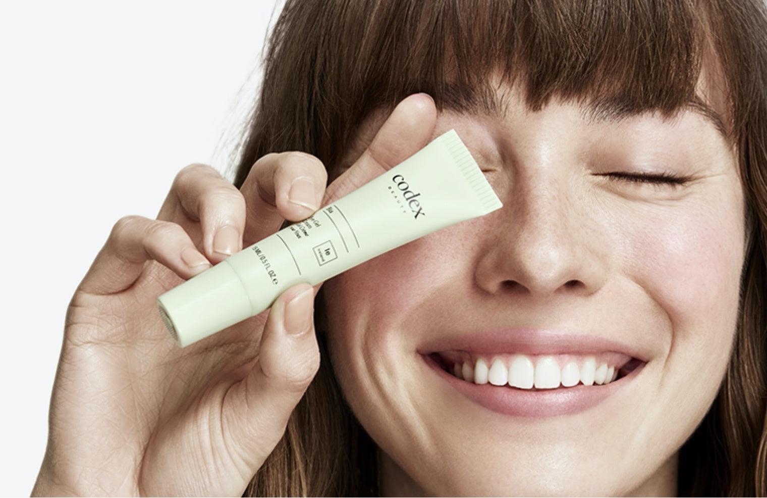 Model holding a Bia Eye Gel Cream to their face